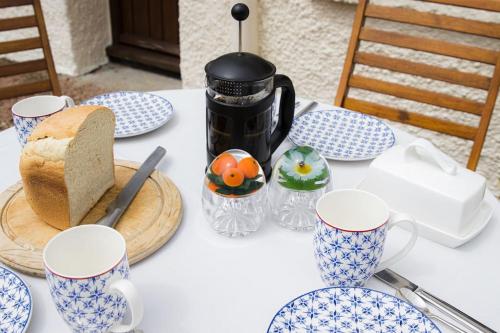 una mesa con tazas y platos azules y blancos. en Batney Farm Cottage, Meshaw, South Molton, en South Molton
