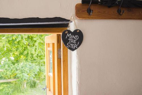 a sign on the side of a door next to a window at Batney Farm Cottage, Meshaw, South Molton in South Molton