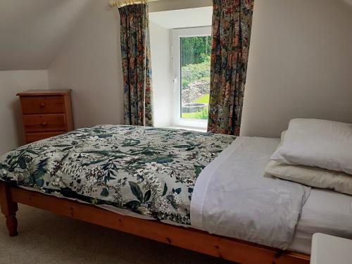 a bedroom with a bed and a window at Lackaroe Cottage in Garrykennedy