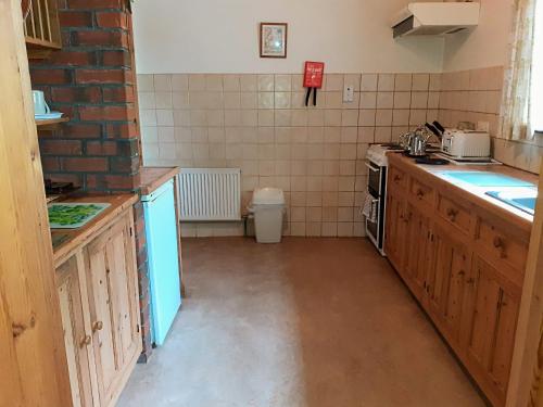 uma pequena cozinha com um lavatório e um fogão em Fraoch Cottage em Garrykennedy