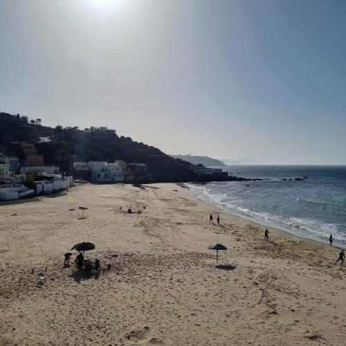 a beach with umbrellas and people on the beach at Rychance Playa Blanca Tanger in Tangier