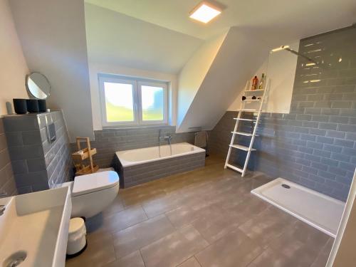 a bathroom with a toilet and a tub and a sink at 3100 - Kuhns Strandhus Grömitz in Grömitz