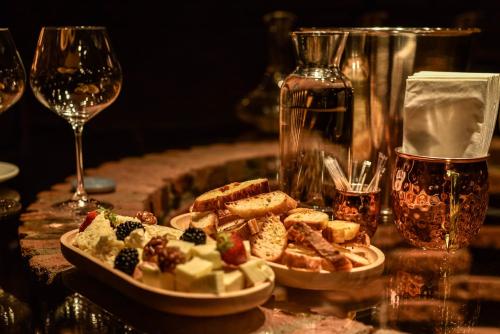 a table with a plate of food and a glass of wine at Boutique Hotel Kviria in Tʼelavi
