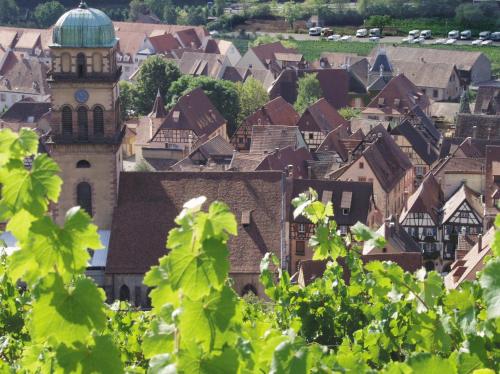 a view of a town with a clock tower at Hotel Les Remparts in Kaysersberg