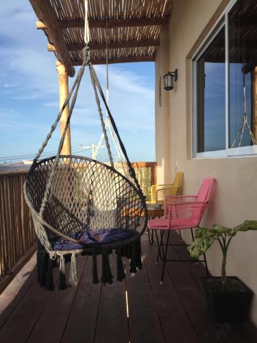 a swing on a porch with a table and chairs at Corazon Mexicano Holbox in Holbox Island