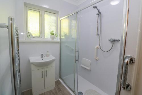 uma casa de banho com um chuveiro e um lavatório. em Yngywidden em Penzance