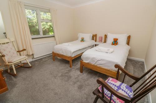 um quarto com 2 camas, uma cadeira e uma janela em Yngywidden em Penzance