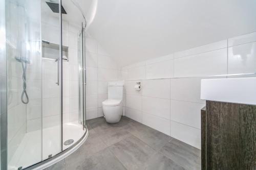 a white bathroom with a shower and a toilet at 14 Helena House One Bedroom Apartment in Reading