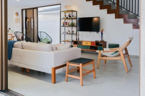 a living room with a white couch and a tv at Casa de Praia Areia Vermelha in Cabedelo