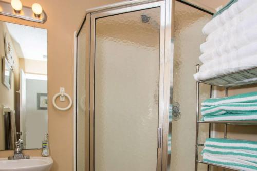 een douche met een glazen deur in de badkamer bij Gulf Island Condominium 722 in Navarre