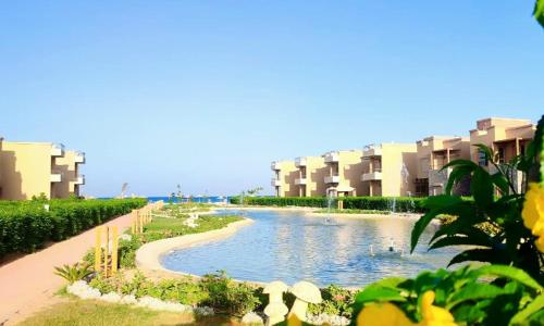 a river in front of some apartment buildings at Cozy Chalet in El Ain El Sokhna شالية بالعين السخنة in Ain Sokhna