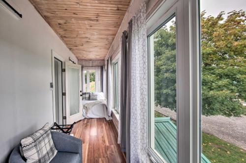 a screened porch with a couch and a large window at Remote Escape Halifax Farmhouse with Pool and Hot Tub in New Buffalo