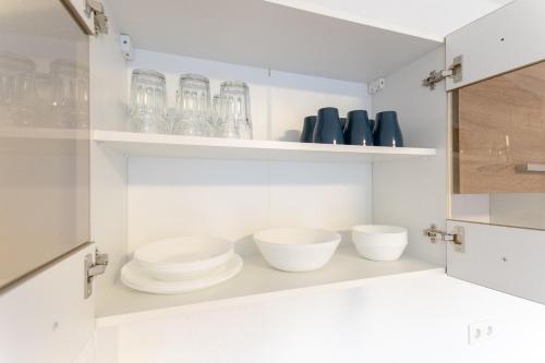 a kitchen with bowls and glasses on shelves at RAJ Living - 1 Room Monteur Apartments - 25 Min Messe DUS in Duisburg
