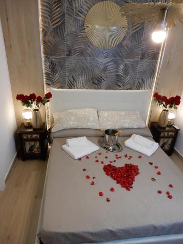 uma cama com pétalas de rosa vermelhas em Caserta Royale Suite em Caserta