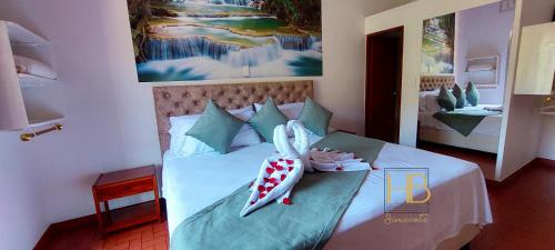 a bedroom with a bed with towels on it at HOTEL BOUTIQUE SIMACOTA in Simacota