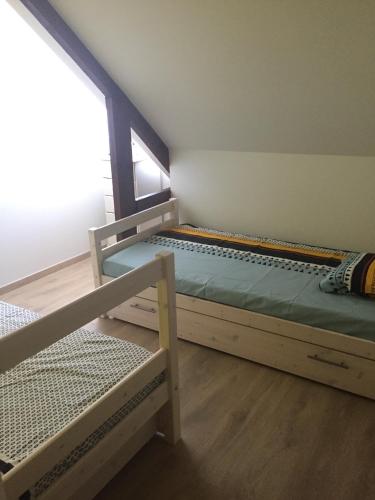 1 Schlafzimmer mit 2 Etagenbetten und einem Fenster in der Unterkunft Bel appartement duplex L'OPALE classé 3* 8P in Étaples