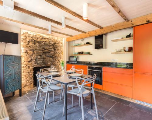 cocina con mesa, sillas y pared de piedra en Crow's Nest, en Port Isaac