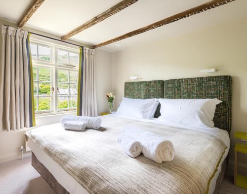 a bedroom with a large bed with towels on it at Crow's Nest in Port Isaac