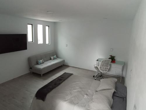 Biały salon z kanapą i telewizorem w obiekcie Habitación Platino comfort y elegancia en Pachuca 