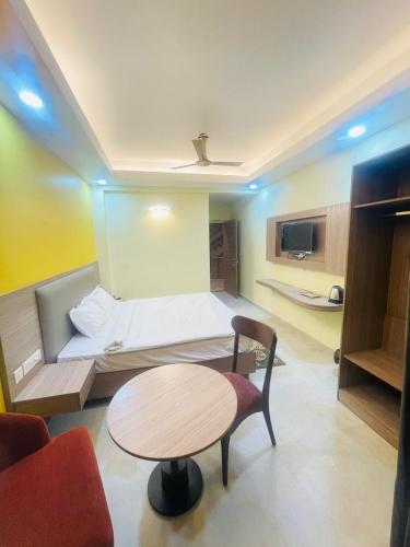 a room with a bed and a table and a couch at Royal Beach International in Puri