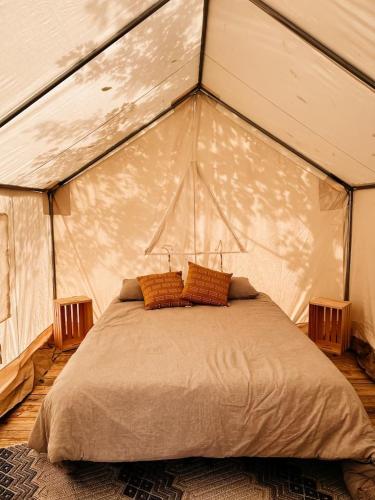 a bedroom with a large bed in a tent at Tentrr Signature Site - Piney Pond Retreat at Tuckaway Tree Farm in Petersburg