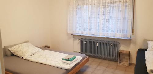 Habitación pequeña con cama y ventana en Joanna Apartment - Schwetzingen 2 en Schwetzingen