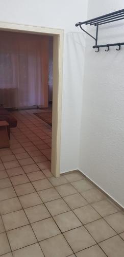 um quarto com piso em azulejo e uma parede branca em Joanna Apartment - Schwetzingen 2 em Schwetzingen