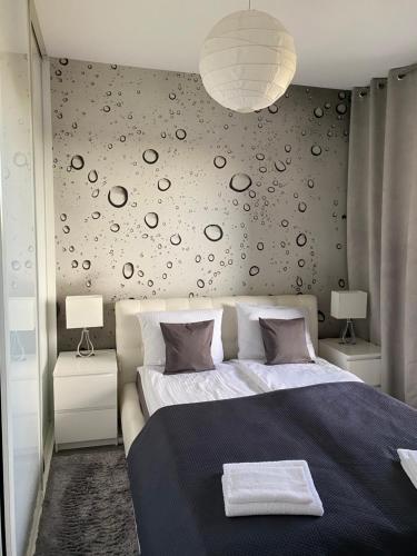 a bedroom with a large bed and a wall with planets at Apartament Winnica in Toruń