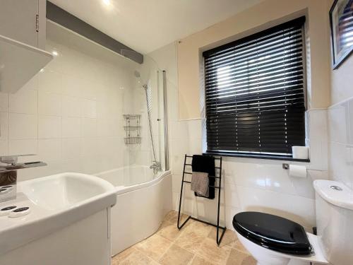 a bathroom with a sink and a toilet and a tub at Arthurs Cottage -Charming Courtyard Cottage in the heart of Kendal, The Lake District in Kendal