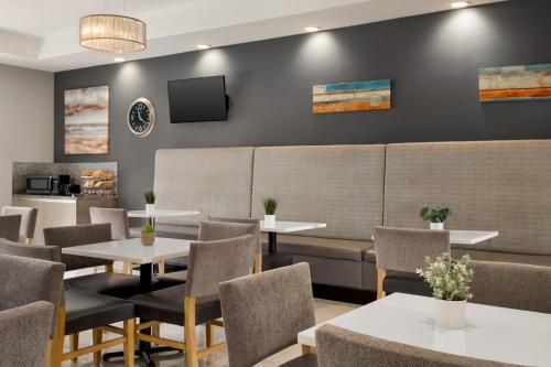 a restaurant with tables and chairs and a tv at La Quinta by Wyndham Brownsville North in Brownsville