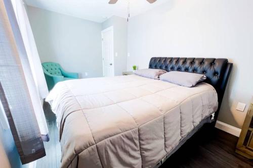 a bedroom with a large bed with a leather headboard at The Haines Villa in Niagara Falls