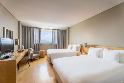 Cette chambre comprend deux lits et une télévision. dans l'établissement The Lince Azores, à Ponta Delgada