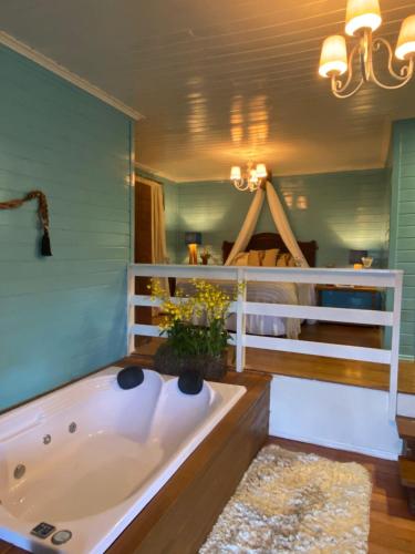 bañera en una habitación con dormitorio en Reserva da Collina, en Gramado