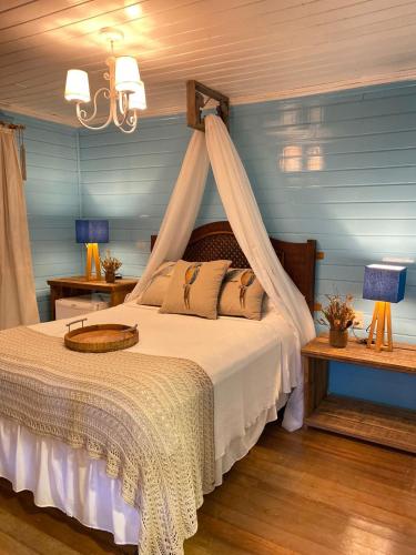 um quarto com uma cama de dossel em Reserva da Collina em Gramado