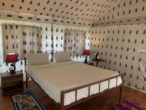 a bedroom with a bed in a room with a wall at Agra Camps and Resort in Agra