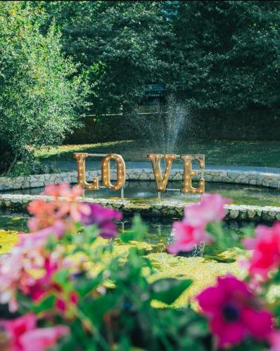 a sign that says love in a garden with flowers at The Parkview Hotel in Newtown Mount Kennedy
