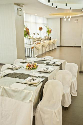 a room with white tables and white chairs and tablesearcher at The Exchange Regency Residence Hotel Managed by HII in Manila