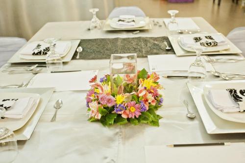 a table with a white table cloth with a bouquet of flowers at The Exchange Regency Residence Hotel Managed by HII in Manila