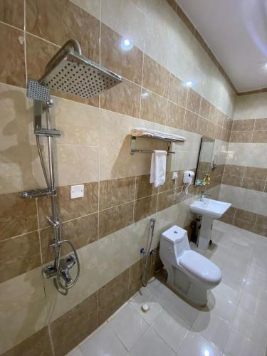 a bathroom with a toilet and a sink at جوهرة السراة للأجنحة الفندقية in Khamis Mushayt