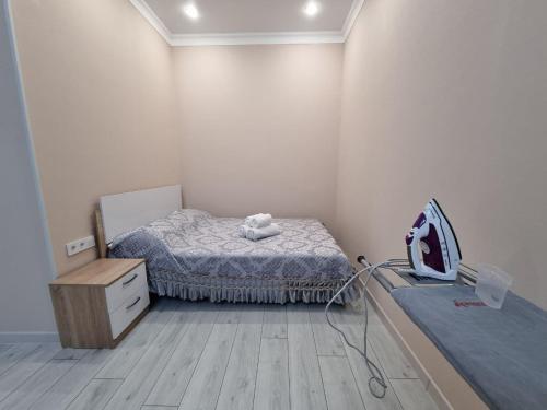 een kleine kamer met een bed en een commode bij 1 комнатная рядом c EXPO, Mega Silk Way in Astana