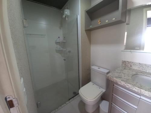 y baño con ducha, aseo y lavamanos. en Flat Duo JK. Lindo e completo, en São José do Rio Preto
