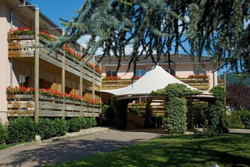 a white tent in front of a building with flowers at Hotel Les Remparts in Kaysersberg
