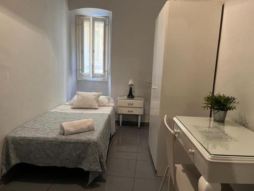 バルセロナにあるHostal Parisien Las Ramblasの白い小さな客室で、ベッド1台とシンクが備わります。