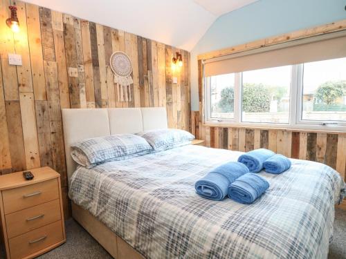 a bedroom with a bed with blue towels on it at The Shack in Norwich