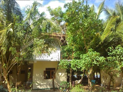 a house in the middle of a bunch of trees at Fishermens Lodge & Restaurant in Ranna