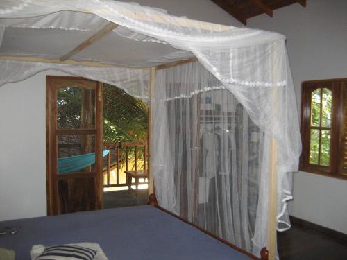 a bedroom with a canopy bed with a balcony at Fishermens Lodge & Restaurant in Ranna