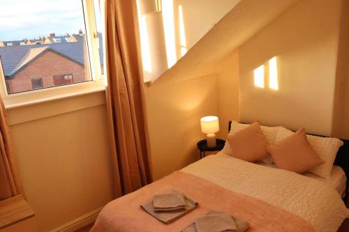 a small bedroom with a bed and a window at Cozy Family Stay with Free Parking and WiFi in Knowsthorpe