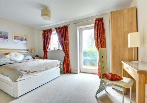 a bedroom with a bed and a desk and a window at The Lookout in Saundersfoot