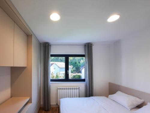 1 dormitorio con cama y ventana en Royal Maison Apartments, en Cluj-Napoca