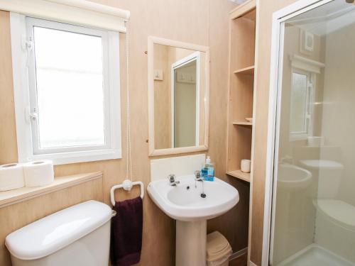 a bathroom with a sink and a toilet and a mirror at 3 Old Orchard in Much Wenlock